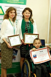 Isaak Mustopulo, a 5th grader from Taraz and author of one of the winning projects, with his mother Maya Mustopulo (standing behind), who is also the founder of the Batul Ana Society of Parents of Children with Disabilities, and Victoria Shestel, director of the department of development of the Public Fund “Dostizheniya Molodykh” and teacher at the Dostar School.